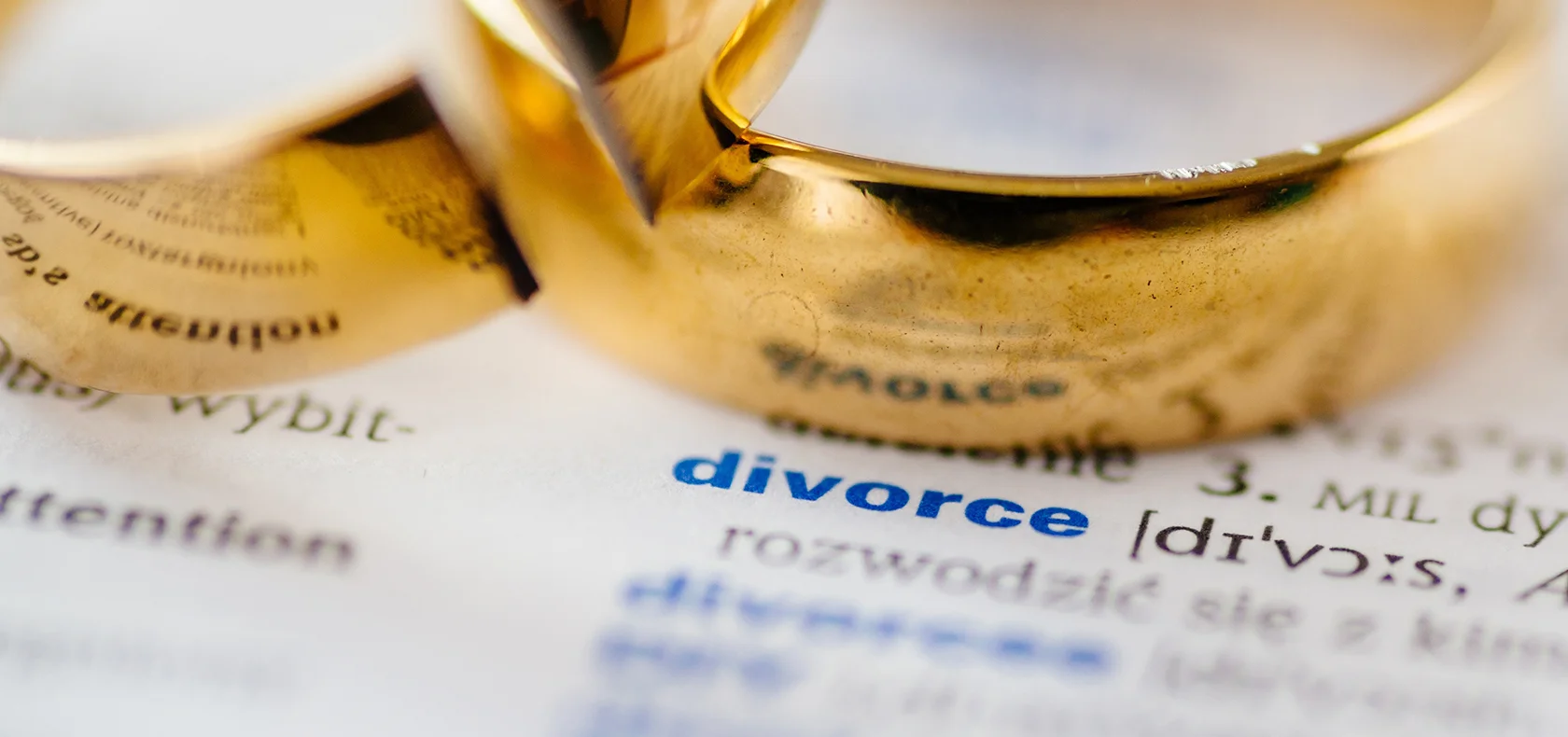 Divorce agreement with wedding rings and couple seated across the table
